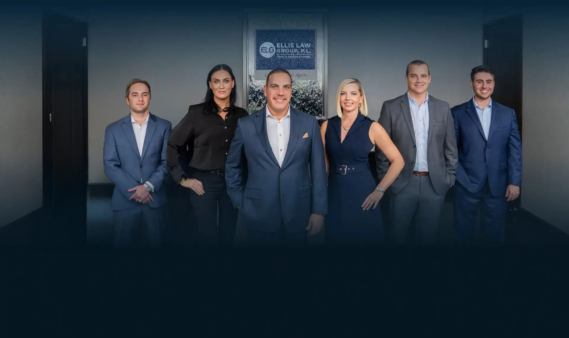 Ellis Law Group team portrait featuring attorneys and legal staff standing in a professional office setting with the Ellis Law Group, P.L. sign displayed in the background.